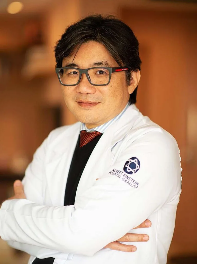 Dr. Flávio Iizuka, urologista, de jaleco branco e braços cruzados